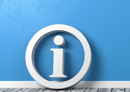 Info-symbol på et grått tregulv mot en blå vegg - Klikk for stort bilde